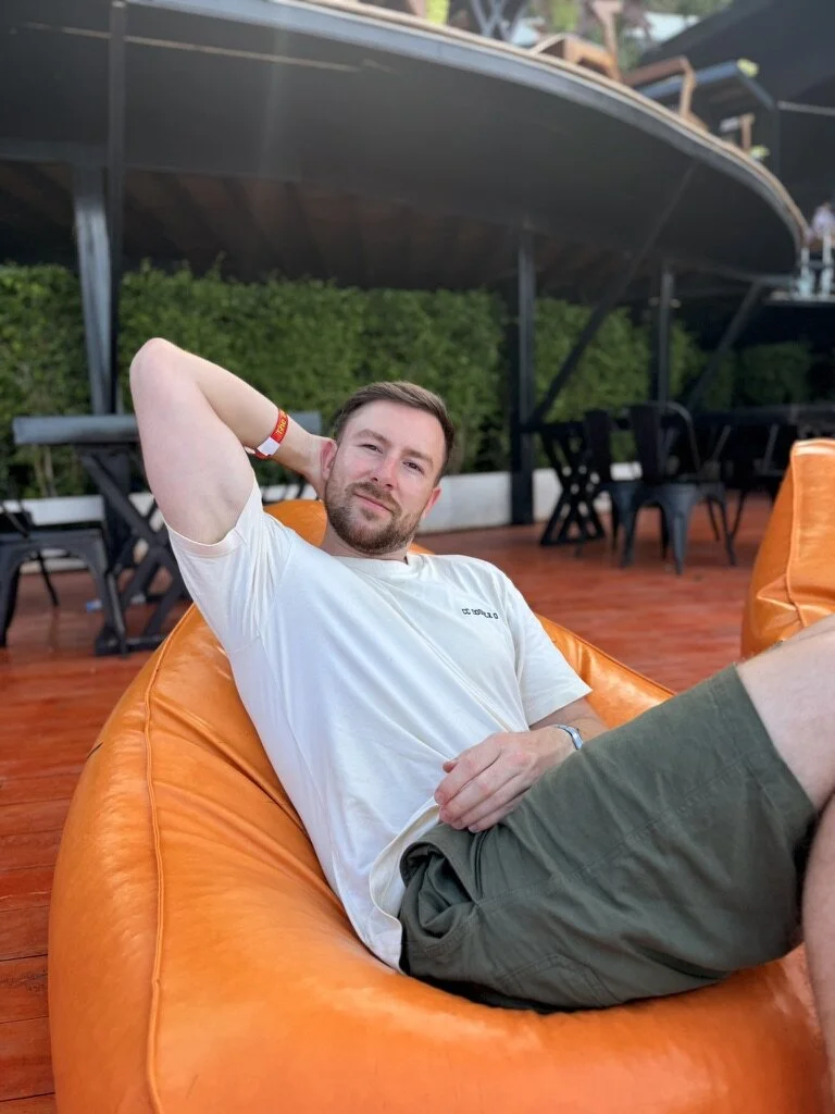 Man reclining outdoors in a white shirt before a change of scene