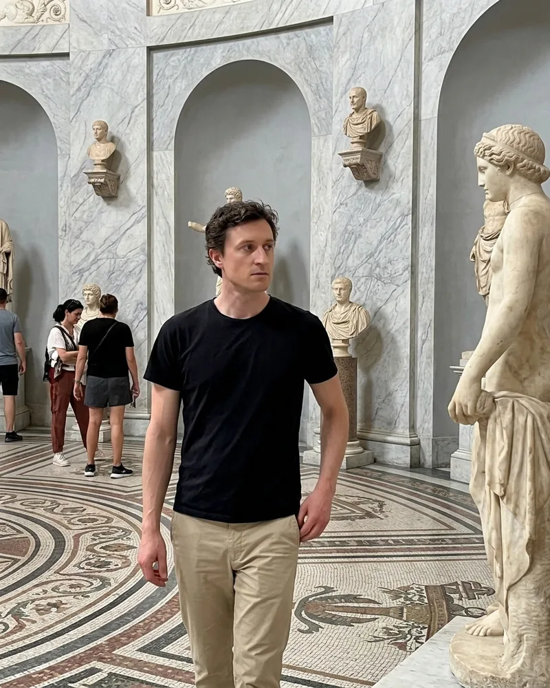 Man walking through a sculpture gallery